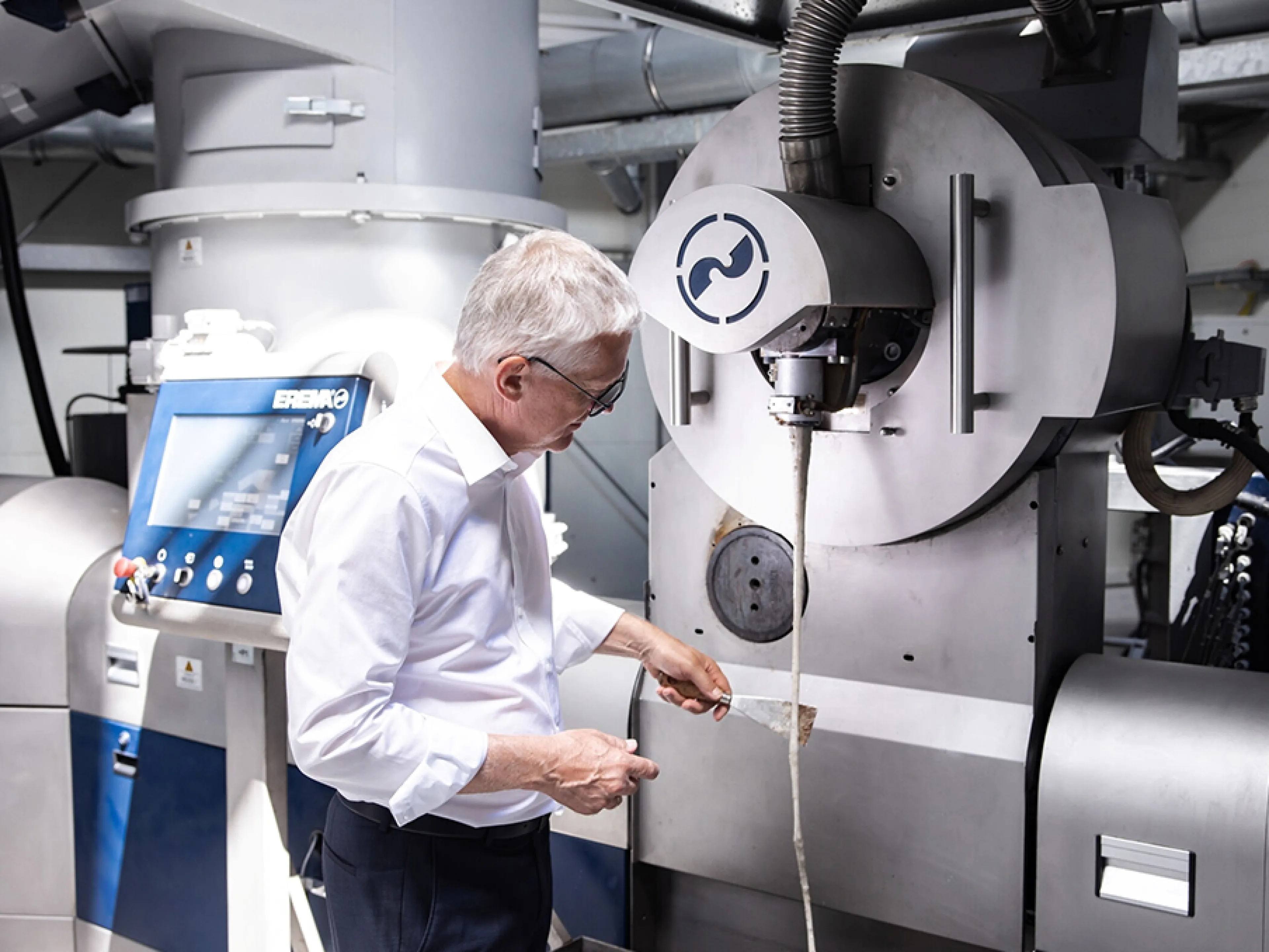 Manfred Hackl, CEO der Erema Gruppe, prüft den Austrag des Schmelzefilters einer Intarema-Anlage. Mit leistungsfähiger Recyclingtechnologie und kontinuierlicher Forschung und Entwicklung sieht sich das Unternehmen für die nächste Wachstumsphase des Kunststoffrecycling gut gerüstet