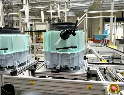 Die hellgrüne und graue Gehäusehälfte werden verschweißt und umschließen in der fertig montierten Waschmaschine die Waschtrommel. Beide Spritzgießteile produziert BSH in Polen seit kurzem in der eigenen Spritzgießerei, Bild: Wittmann Die hellgrüne und graue Gehäusehälfte werden verschweißt und umschließen in der fertig montierten Waschmaschine die Waschtrommel. Beide Spritzgießteile produziert BSH in Polen in der eigenen Spritzgießerei auf Wittmann-Spritzgießmaschinen