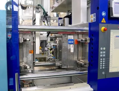 Beide Spritzgießmaschinen sind mit Rolle-zu-Rolle-Folienvorschubeinheiten ausgerüstet. Die Roboter tragen eine Folien-Wärmeplatte und gegenüber davon den Sauggreifer zur Fertigteil-Entnahme