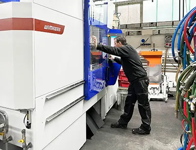 Fertigungsleiter Christian Cassierer an der Produktionszelle, die die Prozesse einfacher und effizienter macht, Bild: Wittmann KB Kunststofftechnik Fertigungsleiter Christian Cassierer an der Produktionszelle