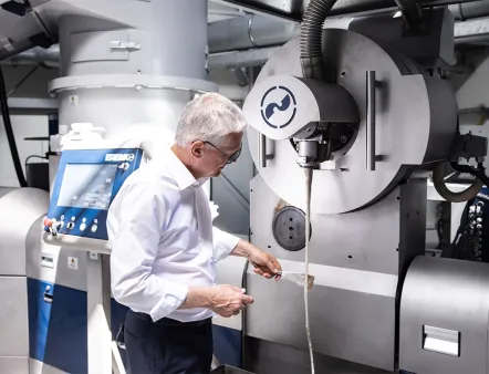 Manfred Hackl, CEO der Erema Gruppe, prüft den Austrag des Schmelzefilters einer Intarema-Anlage. Mit leistungsfähiger Recyclingtechnologie und kontinuierlicher Forschung und Entwicklung sieht sich das Unternehmen für die nächste Wachstumsphase des Kunststoffrecycling gut gerüstet